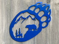 Bear Paw Scenic Metal Sign Cutout - A Powder Coated Metal Sign Featuring a Bear, Trees, and Mountain Silhouette in the Shape of a Bear Paw