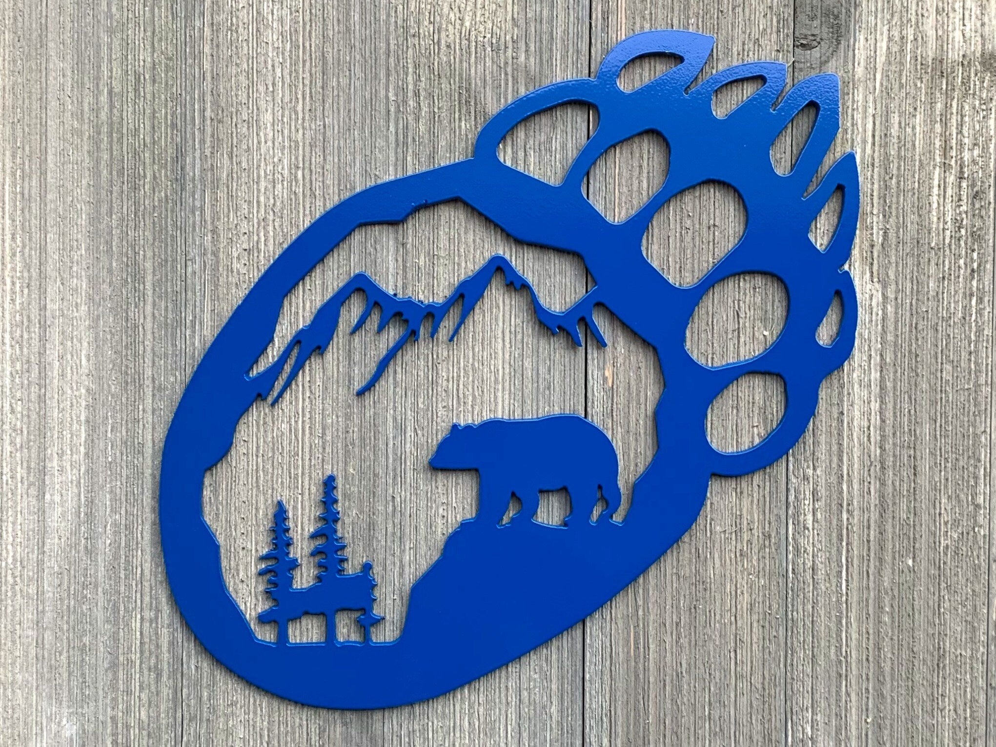Bear Paw Scenic Metal Sign Cutout - A Powder Coated Metal Sign Featuring a Bear, Trees, and Mountain Silhouette in the Shape of a Bear Paw
