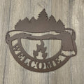 Welcome to the Woods Metal Sign: Axe, Campfire and Tree Silhouette